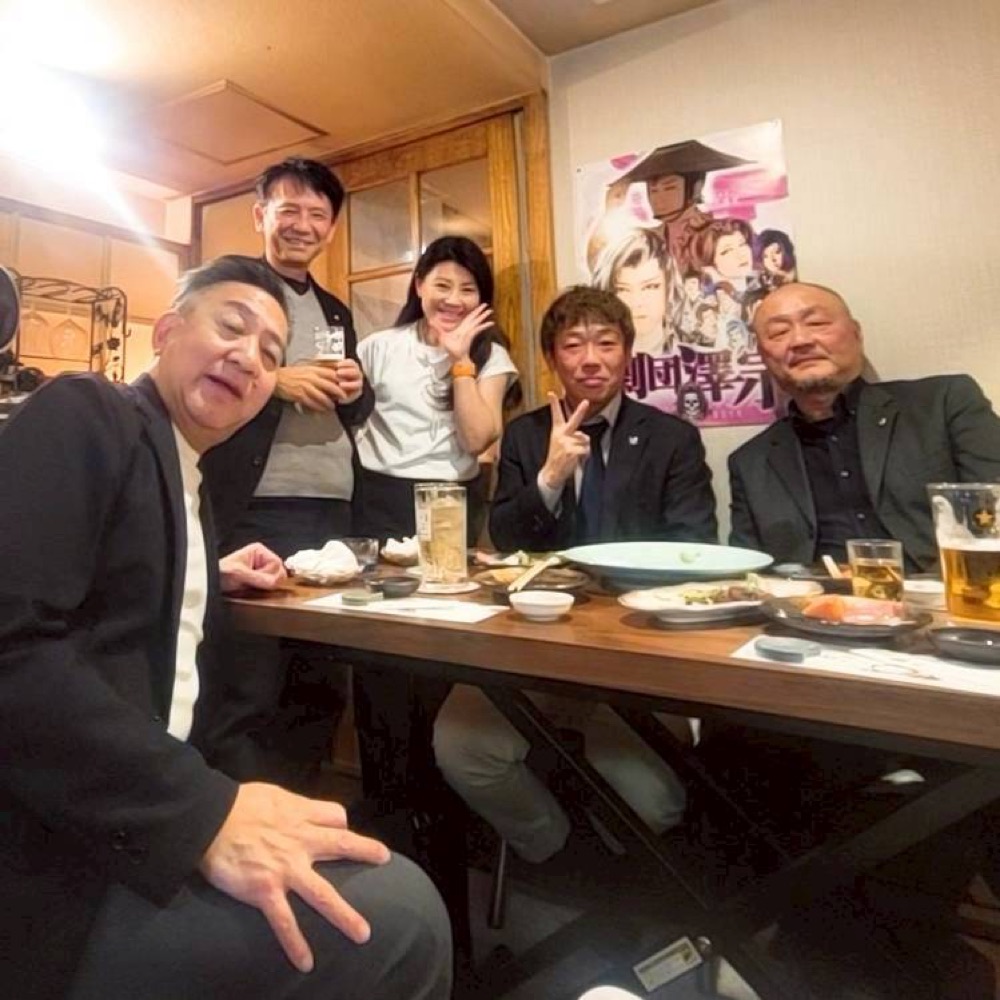 忘年例会で笑顔を見せるメンバーたち